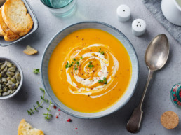 carrot soup surrounded by garnishes