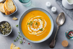 bowl of carrot soup with garnishes